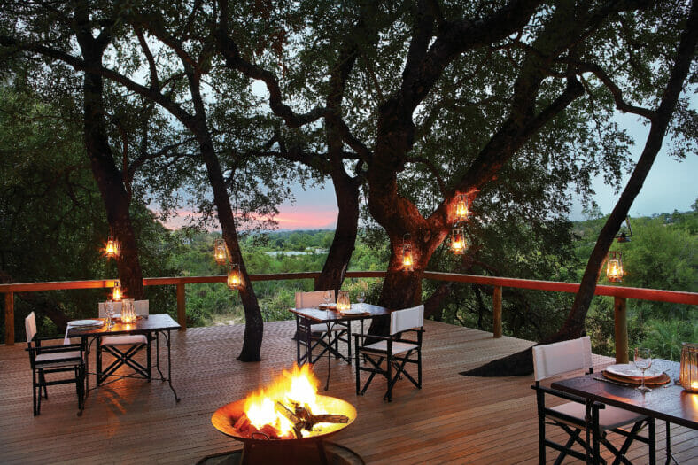 Londolozi Tree Camp Outdoor Dining Deck with Campfire at Dusk