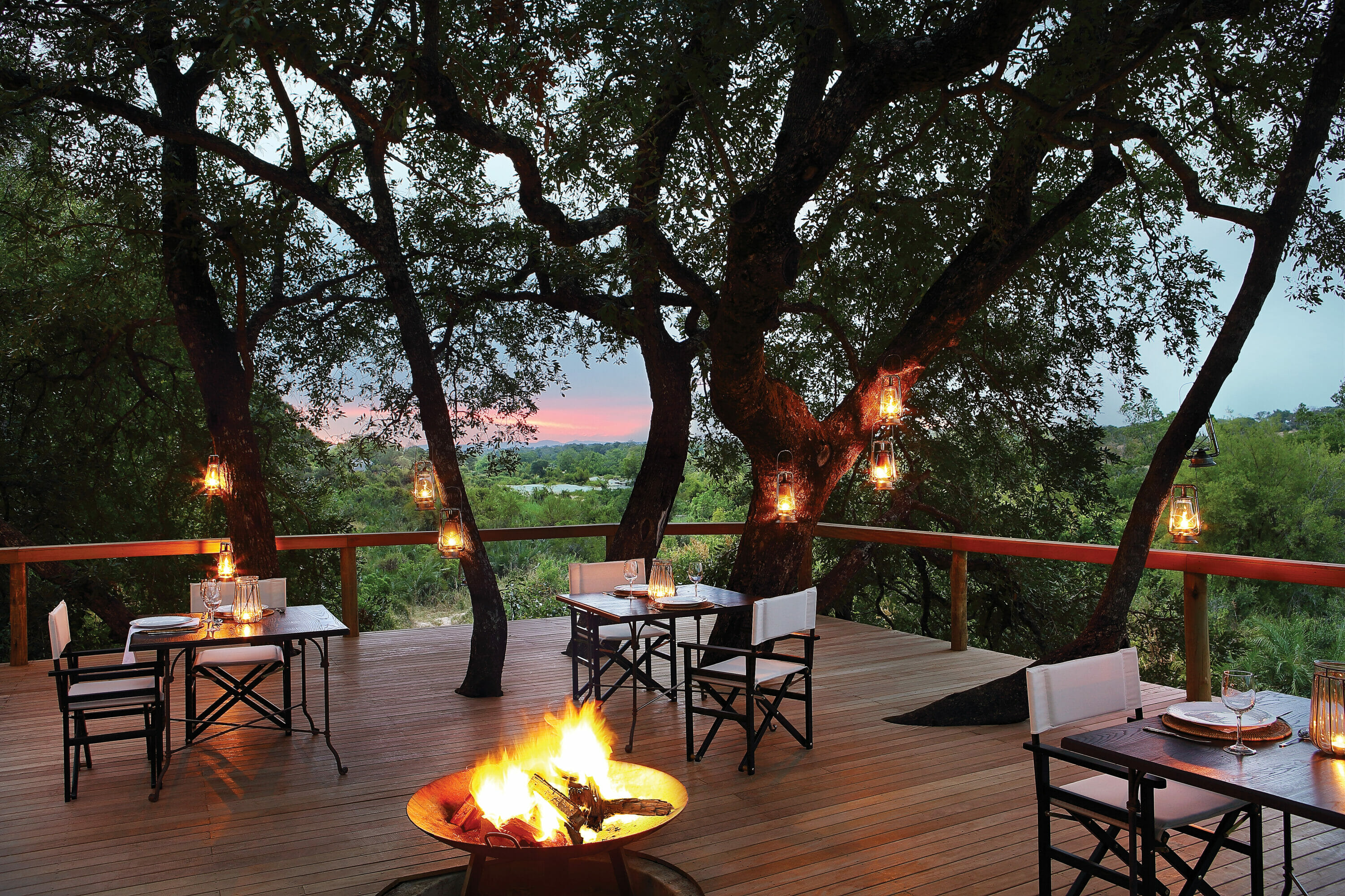 Londolozi Tree Camp Outdoor Dining Deck with Campfire at Dusk