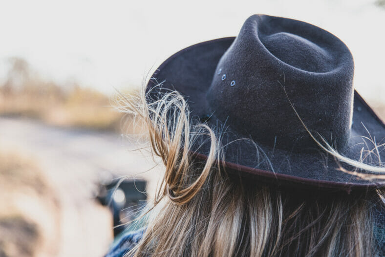 Someone wearing a safari hat, hair blowing in the wind, sense of adventure