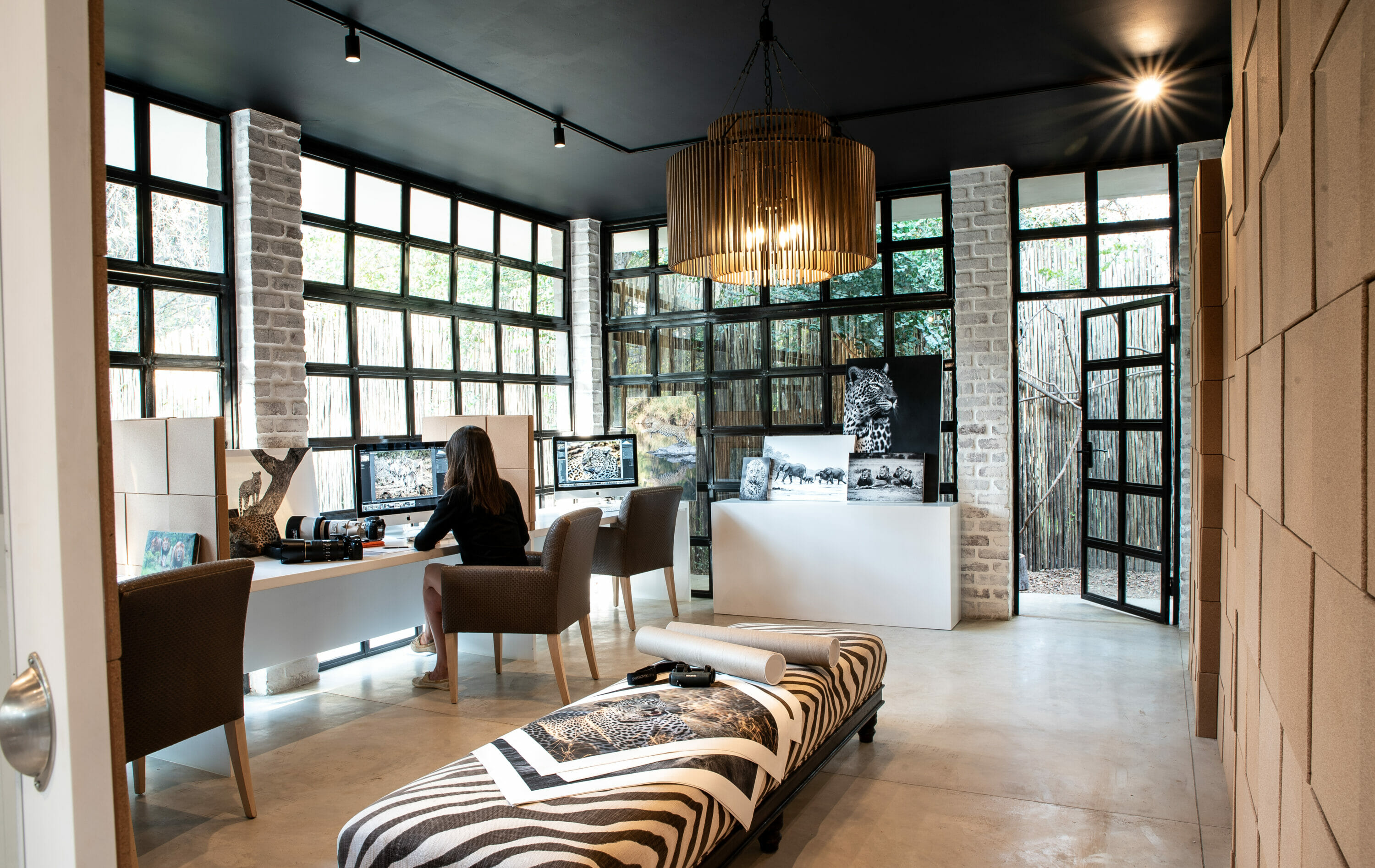 Londolozi photographic studio with desks, comfortably chairs, and iMacs with editing software used by guests on a photographic safari