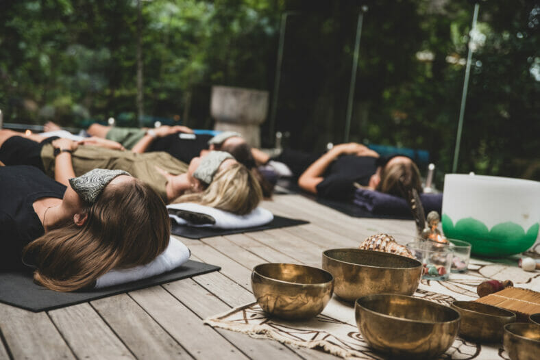 Guests of Londolozi Healing House Safari Retreat meditating on wooden deck
